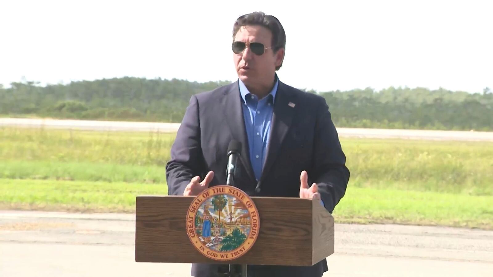 This image from a video feed shows Gov. Ron DeSantis speaking about deportation flights from the remote Everglades immigration lockup known as ”Alligator Alcatraz″ on July 25, 2025 in Ochopee, Florida. (AP Photo via Office Of Florida Governor Ron Desantis)