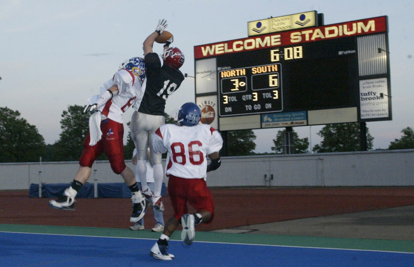 Ken Battiston of Milton-Union goes up for the ball against two defenders, including John Myrick of Dunbar (86), during the 2005 White Allen Pigskin Classic football game at Welcome Stadium. Staff photo by Chris Stewart