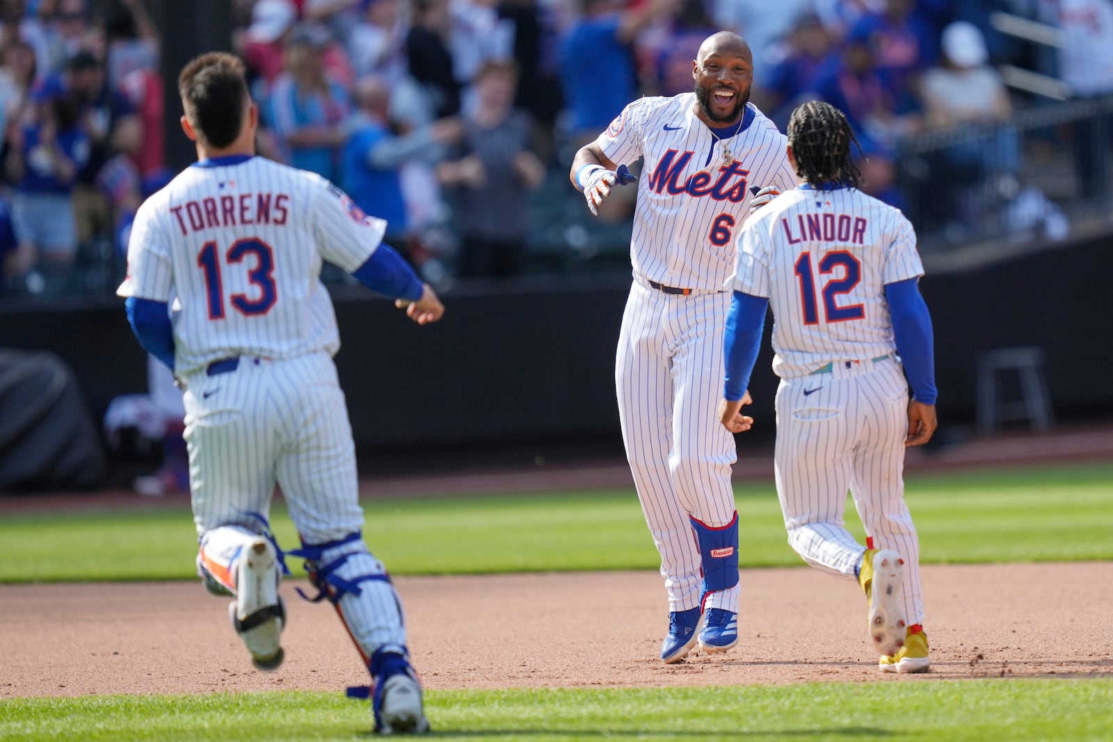 New York Mets' Starling Marte, center, celebrates with teammates after hitting a walk-off single during the tenth inning of a baseball game against the Philadelphia Phillies, Wednesday, April 23, 2025, in New York. (AP Photo/Seth Wenig)