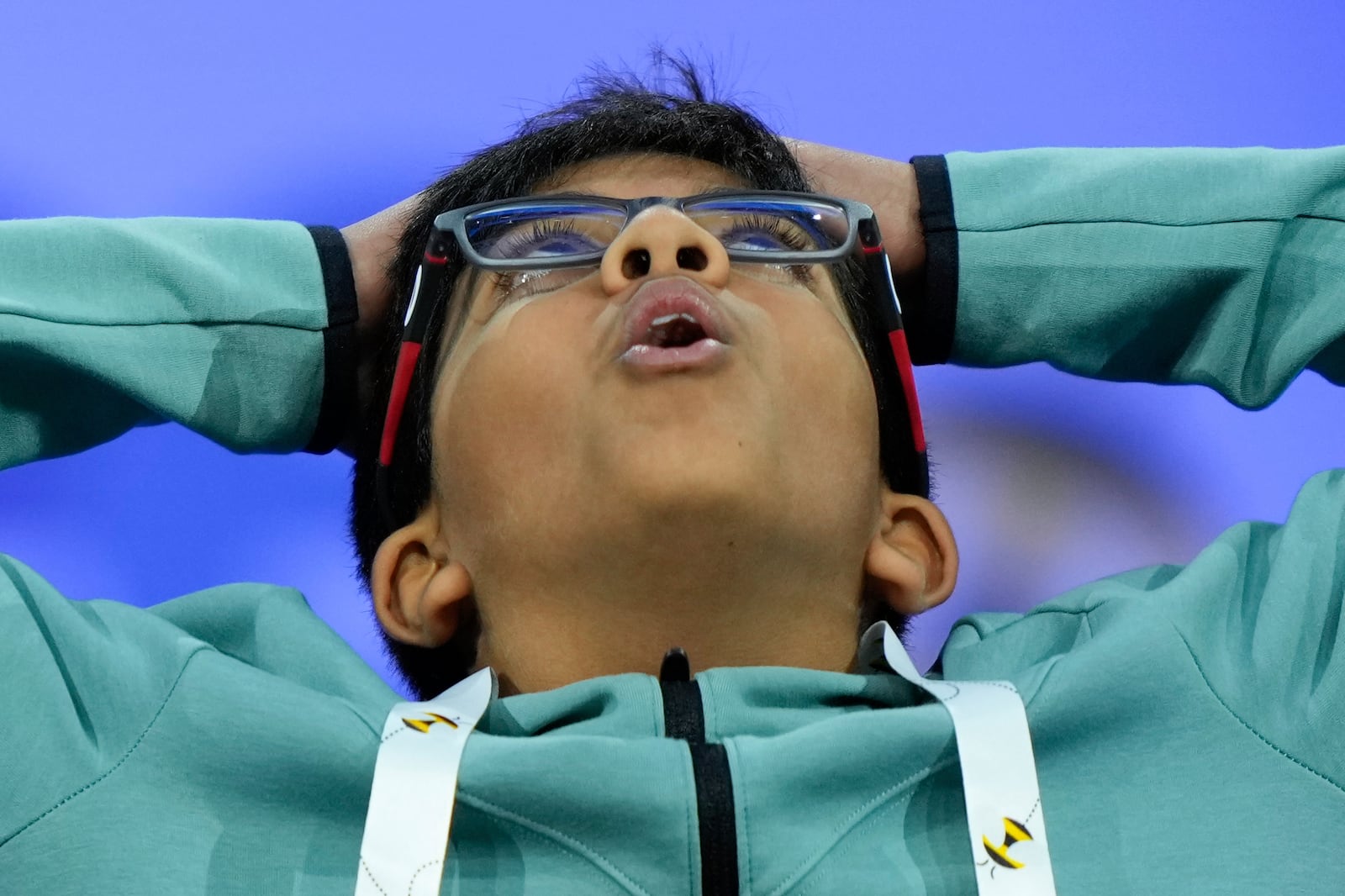 Sach Sarvesh Akella, 12, of Charlotte, N.C., reacts after spelling a word correctly during the quarterfinals of the Scripps National Spelling Bee, Wednesday, May 28, 2025, in Oxon Hill, Md. (AP Photo/Julia Demaree Nikhinson)