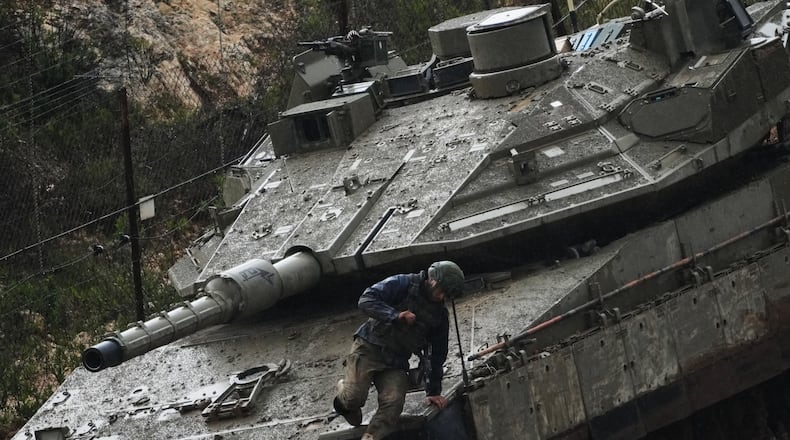 An Israeli soldier jumps from a tank in northern Israel near the border with Lebanon, Saturday, March 21, 2026. (AP Photo/Ariel Schalit)