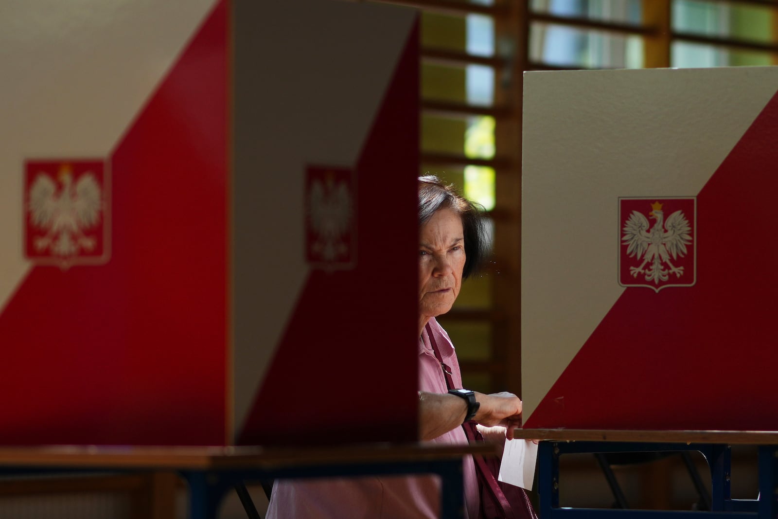 A women prepares to cast her vote during the presidential election runoff in Warsaw, Poland, Sunday, June 1, 2025. (AP Photo/Petr David Josek)