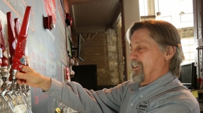 Joe Waizmann pours a beer in the tasting room at Warped Wing Brewing Company at 26 Wyandot St. in downtown Dayton. Staff file photo by JIM WITMER