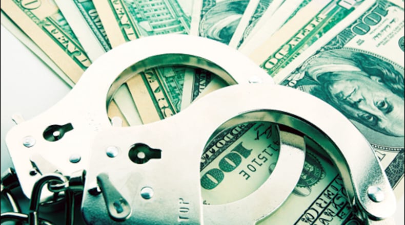 Silver handcuff and dollar bank notes