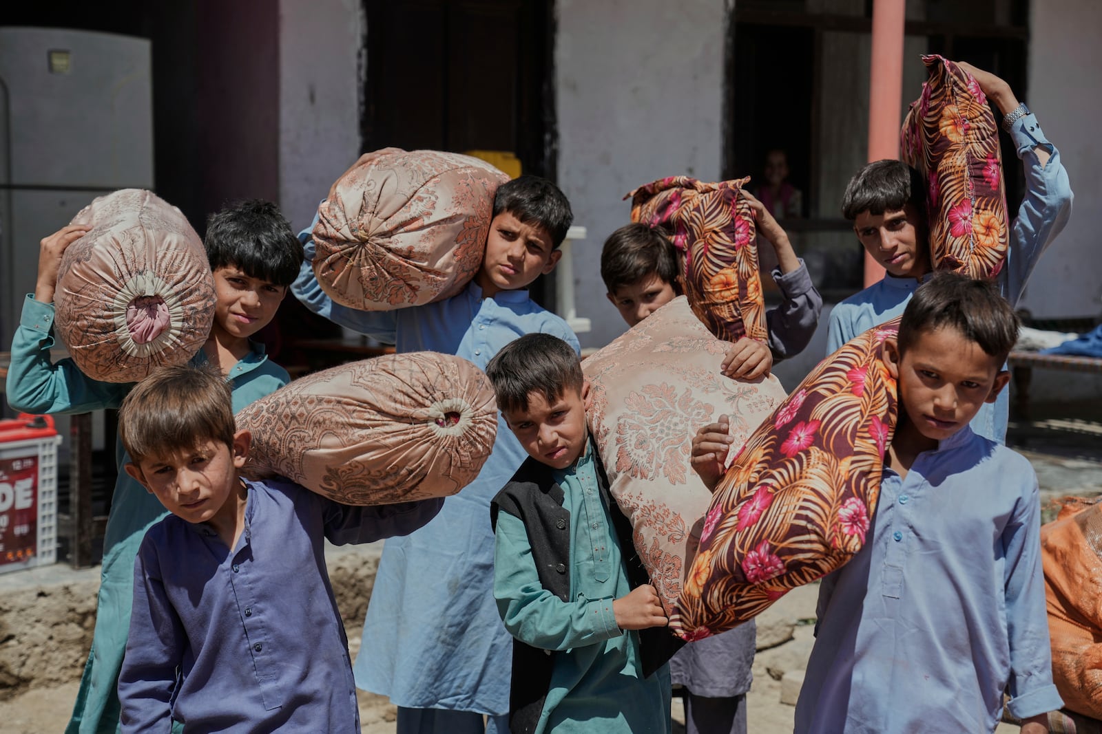 Afghan children from families repatriated from Pakistan carry pillows as they are relocated to their new residence in Kabul, Afghanistan, Tuesday, June 3, 2025. (AP Photo/Ebrahim Noroozi)