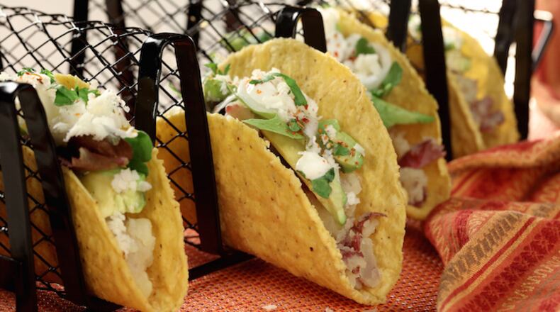 An updated version of hard-shell tacos features the same crispy shells, but with a filling of potatoes, avocado, spring onions, crema and baby lettuce greens. (Michael Tercha/Chicago Tribune/TNS)