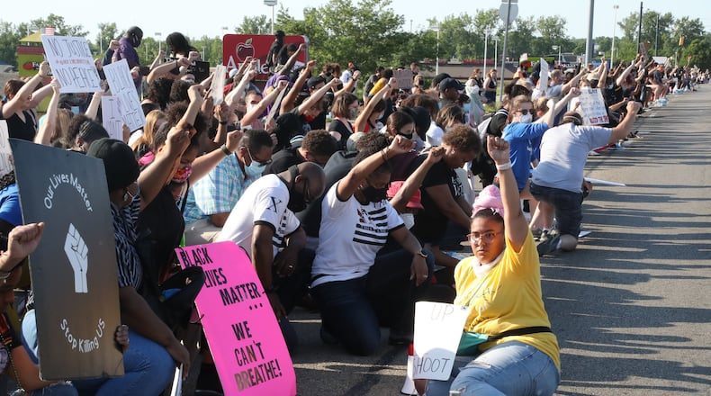 Protestors take a knee at a rally along Old Troy Pike in Huber Heights on Saturday, June 6, 2020. Bill Lackey/STAFF