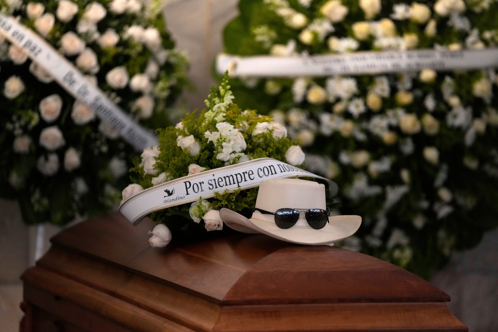 FILE - The hat and sunglasses of Dominican singer Rubby Perez, who died in the roof collapse at the Jet Set nightclub during his merengue concert, sit on his casket during his wake at the Eduardo Brito National Theater in Santo Domingo, Dominican Republic, April 10, 2025. (AP Photo/Matias Delacroix, File)