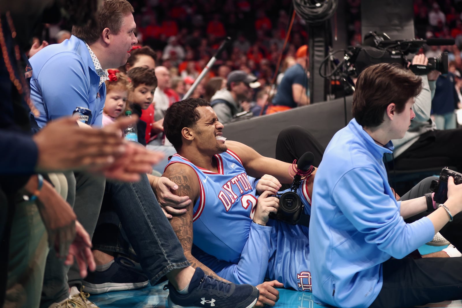 Dayton's De'Shayne Montgomery grimaces after a fall following a shot attempt against Virginia on Saturday, Dec. 6, 2025, at the Spectrum Center in Charlotte, N.C. David Jablonski/Staff