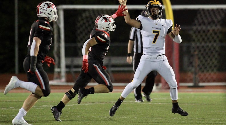 Centerville's Chase Harrison throws a pass as he's pressured by Wayne's Kyle Johnson in a Division I, Region 2 playoff first-round game on Friday, Oct. 9, 2020, in Huber Heights. David Jablonski/Staff