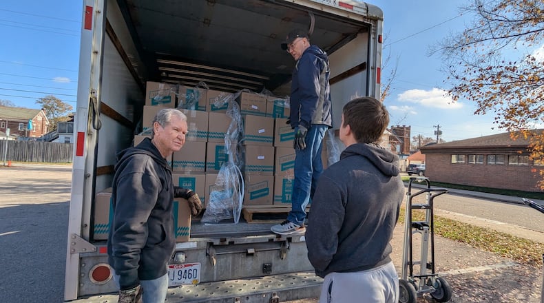 Bob Herbert, Larry Head and Brayden Brem help Miamisburg Helping Hands during an effort that supplied Miamisburg school district families with meal kits on Saturday, Nov. 22, 2025. The kits were supplied by Crossroads Church, whose Miami Twp. site at the Dayton Mall filled 1,056 Thanksgiving meal boxes. CONTRIBUTED