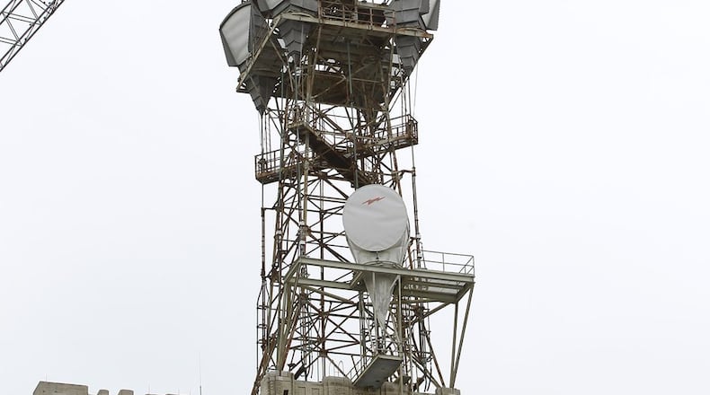 Workers tear down at microwave tower on top of the AT&T building in downtown Dayton. Ty Greenlees