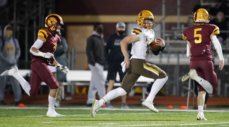 Cutline2: Alter High School quarterback Brian Shane runs past two Ross defenders during their Division III regional final game on Friday night at Ross High School. The Knights won 35-21. Michael Cooper/CONTRIBUTED