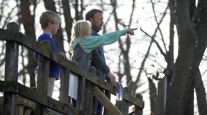 The Funke family, Ryder, left, Sadie and dad Bronson, from Lebanon look over the Little Miami River Valley from Fort Ancient. Fort Ancient Earthworks outside Lebanon is one stop on the Ancient Ohio Trail, a system of Native American heritage sites a retired UC professor is turning into a global tourist attraction. TY GREENLEES / STAFF