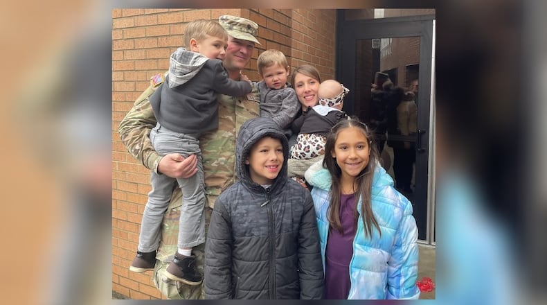 Spc. Ryan Hughes of Urbana takes a photo with his family: wife, Heather, and children Nevayah, 9; Ryken, 8; Yukiah, 4; Ezekiel, 2; and Octavia, 5 months, after a call to duty ceremony Saturday, Feb. 15, 2025, at Franklin Junior High School. JEN BALDUF/STAFF