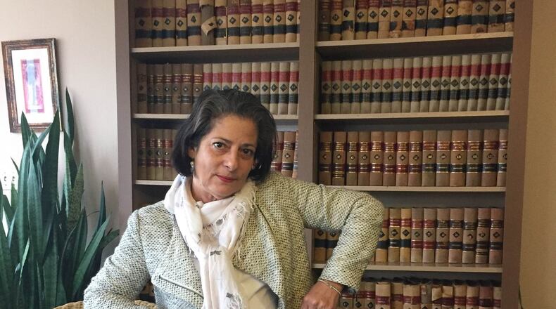 Isabel Suarez, a Dayton attorney, holding up the skirt her mother brought over from Cuba. CONTRIBUTED