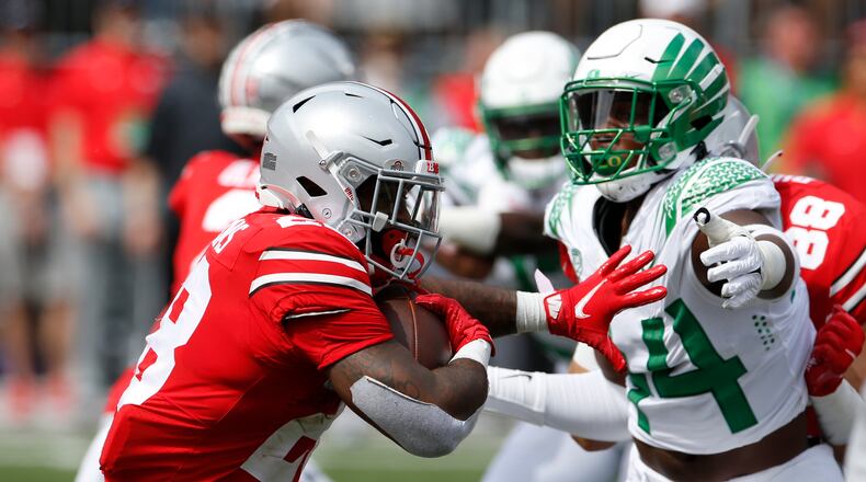 Ohio State running back Miyan Williams, left, tries to run past Oregon defensive lineman Bradyn Swinson during the first half of an NCAA college football game Saturday, Sept. 11, 2021, in Columbus, Ohio. Oregon beat Ohio State 35-28. (AP Photo/Jay LaPrete)