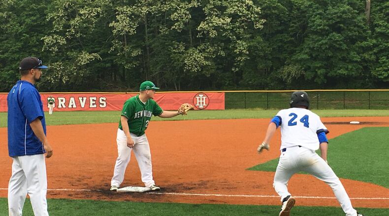 Cincinnati Christian’s Mitchell Smith (24) heads back to third base as New Miami’s Dalton Garrett awaits the throw during Thursday’s Division IV district semifinal at Indian Hill. That’s CCS coach Curtus Moak watching the play. RICK CASSANO/STAFF