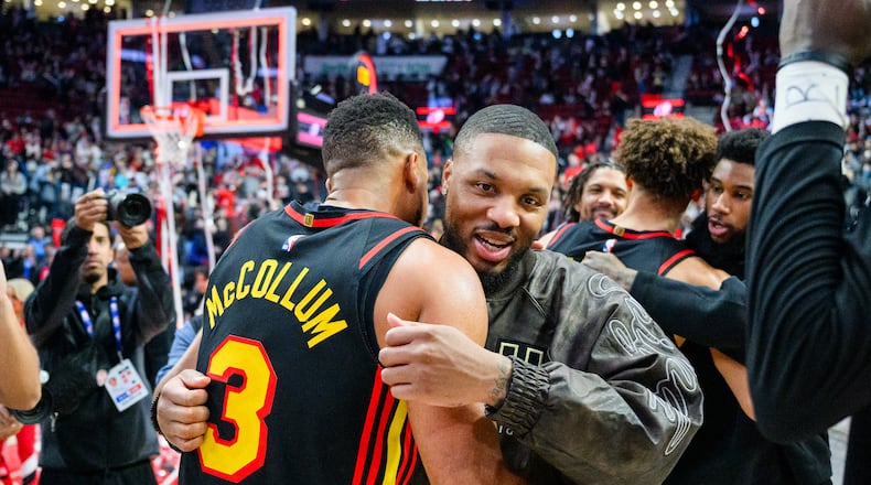 Portland Trail Blazers guard Damian Lillard, right, and Atlanta Hawks guard CJ McCollum, left, embrace after an NBA basketball game on Thursday, Jan. 15, 2026, in Portland, Ore. (AP Photo/Molly J. Smith)