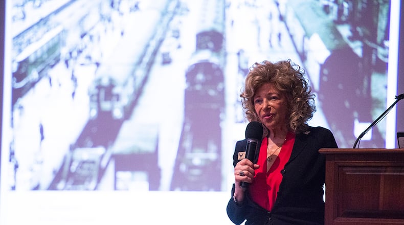 Dr. Renate Frydman delivers remarks as keynote speaker during the Holocaust Remembrance Day event on April 8 at the National Museum of the U.S. Air Force on Wright-Patterson Air Force Base. Frydman said her first memory as a child was boarding a train at Frankfurt Train Station (shown on the screen) to escape Nazi Germany. U.S. AIR FORCE PHOTO/WESLEY FARNSWORTH