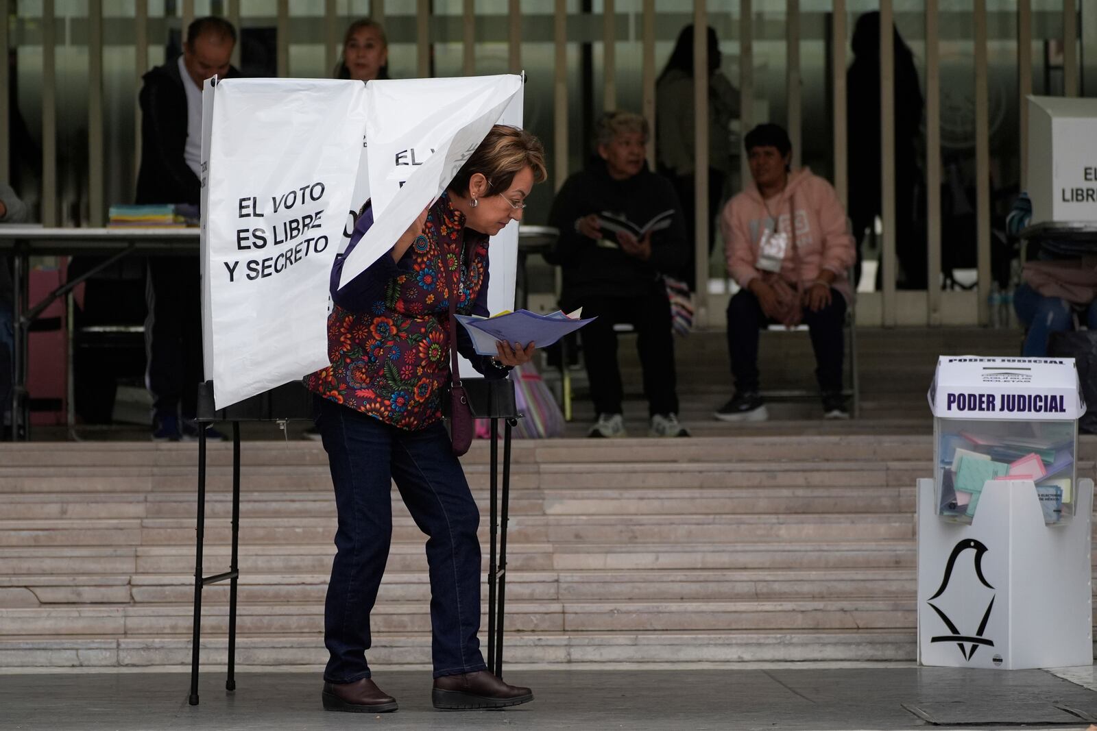 A voter leaves after casting her ballot in Mexico's first judicial elections, in Mexico City, Sunday, June 1, 2025. (AP Photo/Marco Ugarte)