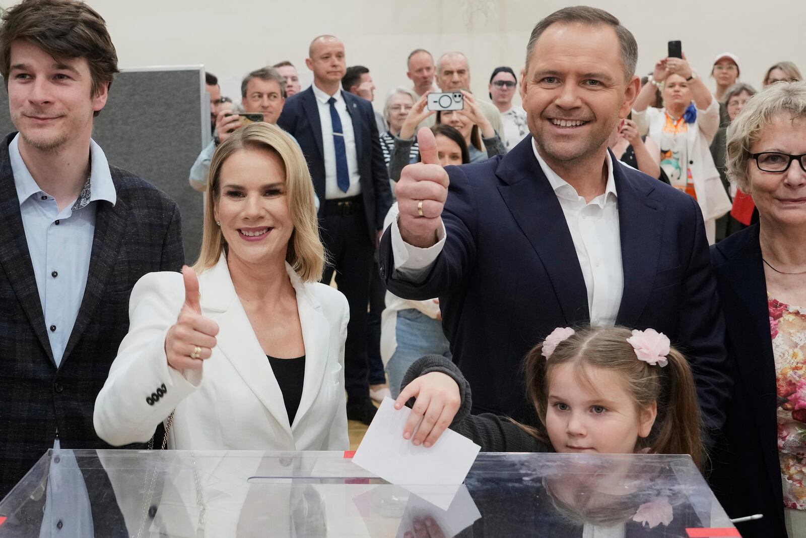 Presidential candidate Karol Nawrocki, second right, poses with his wife Marta Nawrocka, second left, and daughter Katarzyna at a polling station during the presidential election runoff in Warsaw, Poland, Sunday, June 1, 2025. (AP Photo/Czarek Sokolowski)