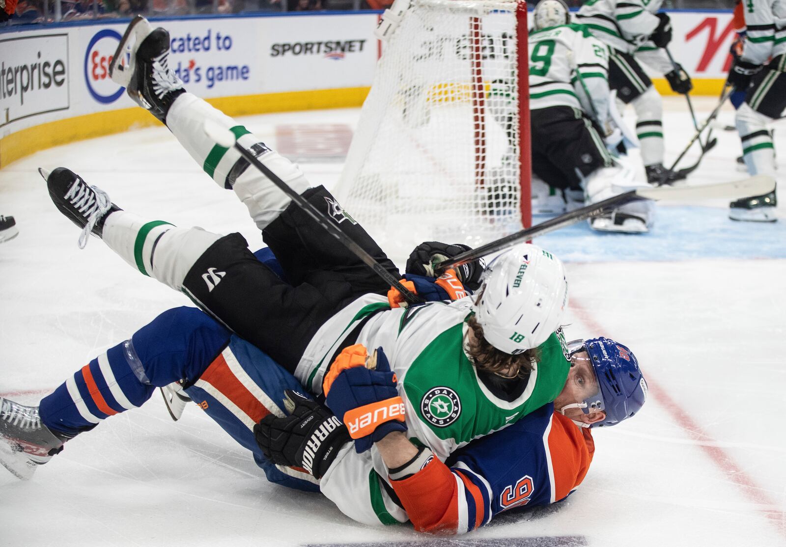 Dallas Stars' Sam Steel (18) and Edmonton Oilers' Corey Perry (90) get tangled up during second period NHL Western Conference final playoff action, in Edmonton on Tuesday, May 27, 2025. (Jason Franson/The Canadian Press via AP)