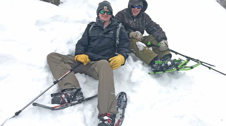 Cole Anderson, left, and Max Kelly relax in snow after hiking on snowshoes to a rocky peak in the Bridger Mountains of Montana. (Dennis Anderson/Minneapolis Star Tribune/TNS)