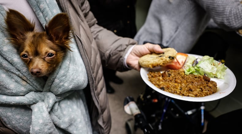 Woo Woo, a miniature chihuahua, is carried by a guest at St. Vincent de Paul Shelter for Women and Families on Apple Street in Dayton Tuesday, Feb. 14, 2023. STAFF
