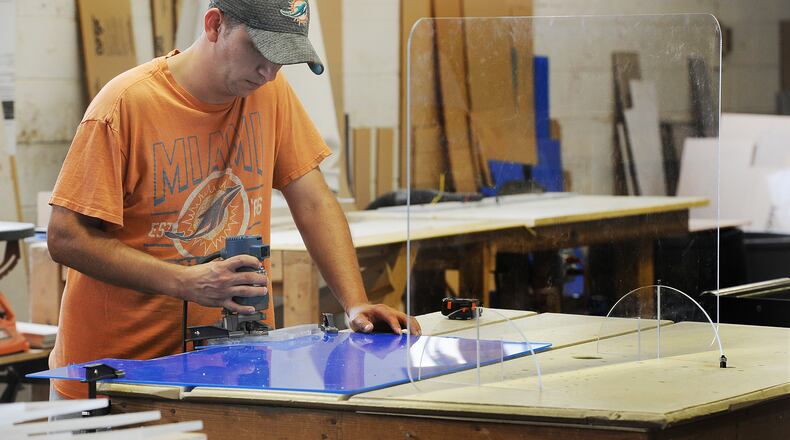 Tim Stewart, an employee of Kohlfab Custom Plastic Fabrication, works on making plexiglass barriers. MARSHALL GORBY\STAFF