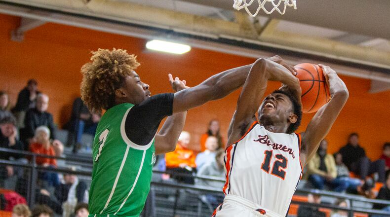 Beavercreek's Kaden Ellerbe is fouled while shooting by Northmont's Da'lin Wilkiuns during Thursday night's game at Beavercreek. Jeff Gilbert/CONTRIBUTED