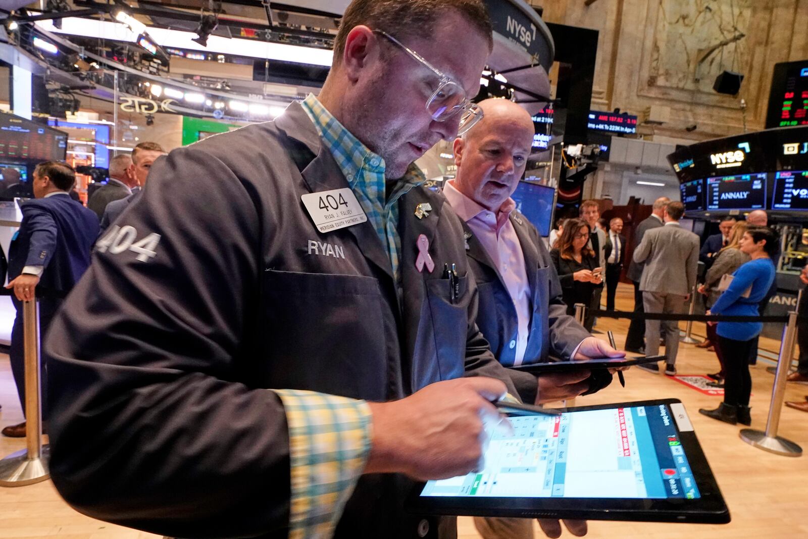Traders Ryan Falvey, left, and Patrick Casey work on the floor of the New York Stock Exchange, Thursday, April 10, 2025. (AP Photo/Richard Drew)
