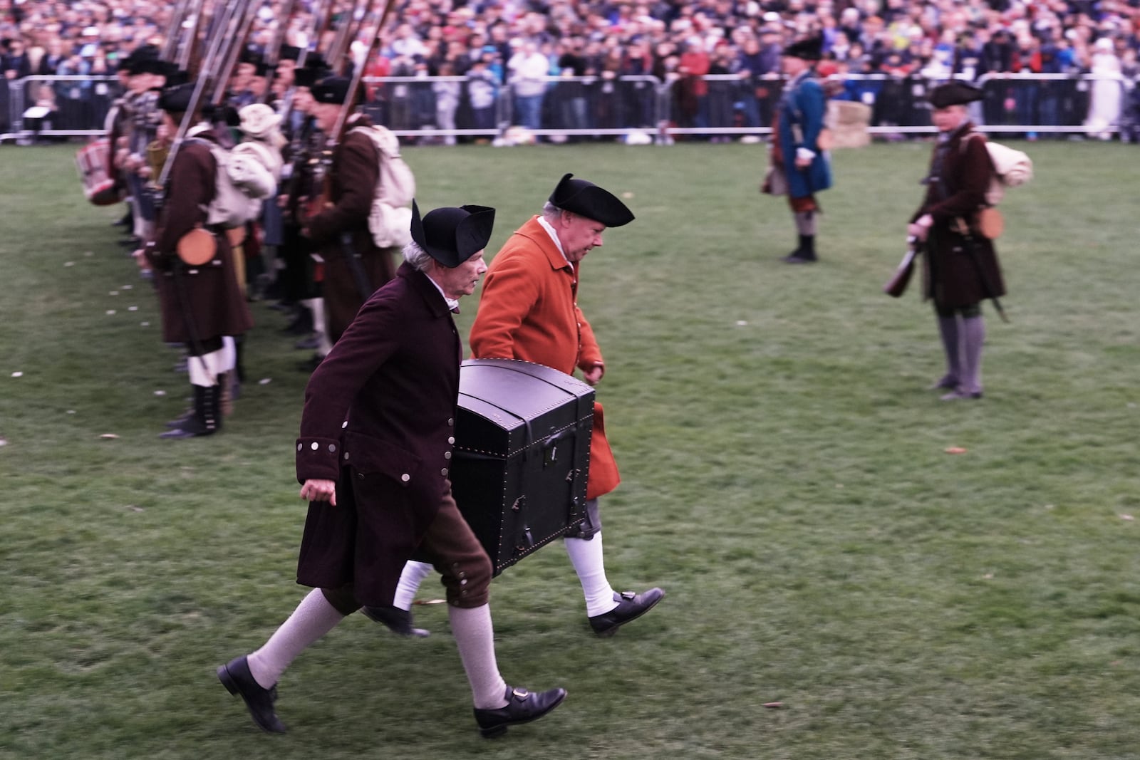 Colonial men carry the papers of John Hancock away from the advancing British Regulars during a reenactment celebration of the 250th anniversary of the Battle of Lexington and start of the American Revolution, Saturday, April 19, 2025, in Lexington, Mass. (AP Photo/Charles Krupa)