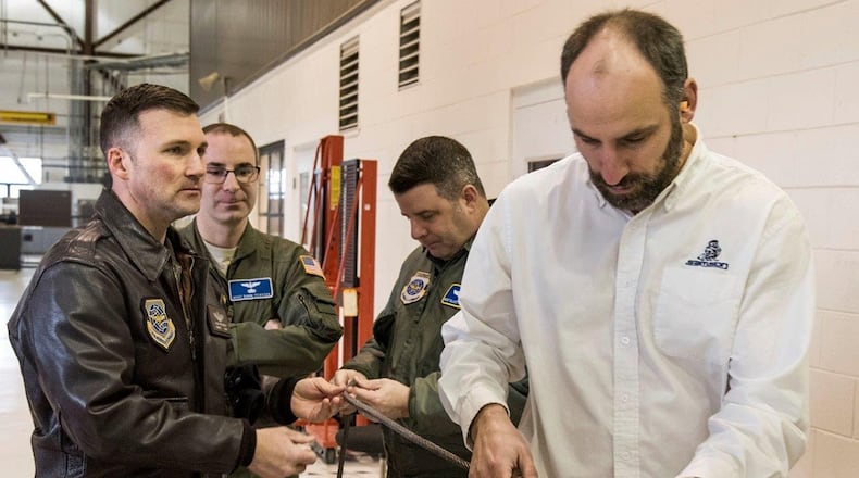Senior Master Sgt. Jeff Witherly, Headquarters, Air Mobility Command C-17 evaluator loadmaster, Scott Air Force Base, Illinois; Master Sgts. David Feaster and Elliott McClanahan, both 3rd Airlift Squadron loadmasters; listen to Justin Smoak, Samson Rope application engineering manager, Ferndale, Washington, discuss the construction of the winch cable. (U.S. Air Force photo/Roland Balik)