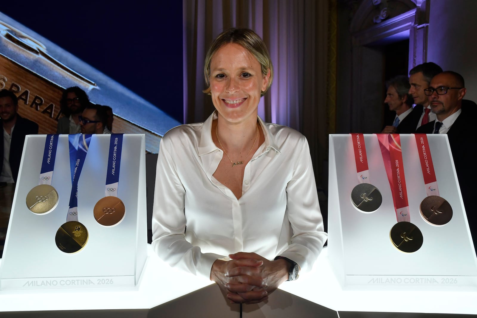Former Italian swimmer Federica Pellegrini poses for photographers next to Milano Cortina 2026 Winter Olympics and Paralympics medals during the unveiling ceremony in Venice, Italy, Tuesday, July 15, 2025. (AP Photo/Luigi Costantini)
