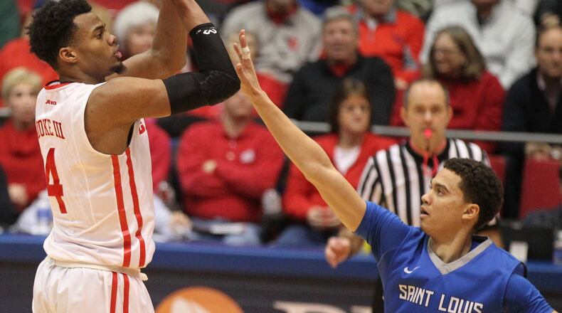 Dayton’s Charles Cooke shoots against Saint Louis guard Davell Roby last season at UD Arena. The Flyers have won five straight against Saint Louis. DAVID JABLONSKI / STAFF