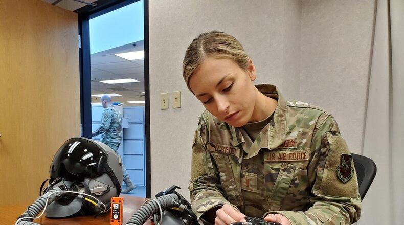 2nd Lt. (Dr.) Dominique O’Brien, project lead, Airman Sensing and Assessment Product Line, with the 711th Human Performance Wing’s Airman Systems Directorate, displays two devices her team used during flight tests in support of a request from the 20th Fighter Wing to provide assistance with assessing cabin pressure, oxygen concentrations and possible hypoxia-like symptoms reported by their F-16 pilots. One device is called the “Slam Stick,” (orange in color), which measures tri-axial acceleration – or acceleration in all three axes: X, Y and Z. The second device is called the Insta Pilot Breath Air Monitor, or IPBAM, (black device being held by Lt. O’Brien) which measures several critical parameters of the breathing gas delivered to the pilot. (U.S. Air Force photo/Bryan Ripple)