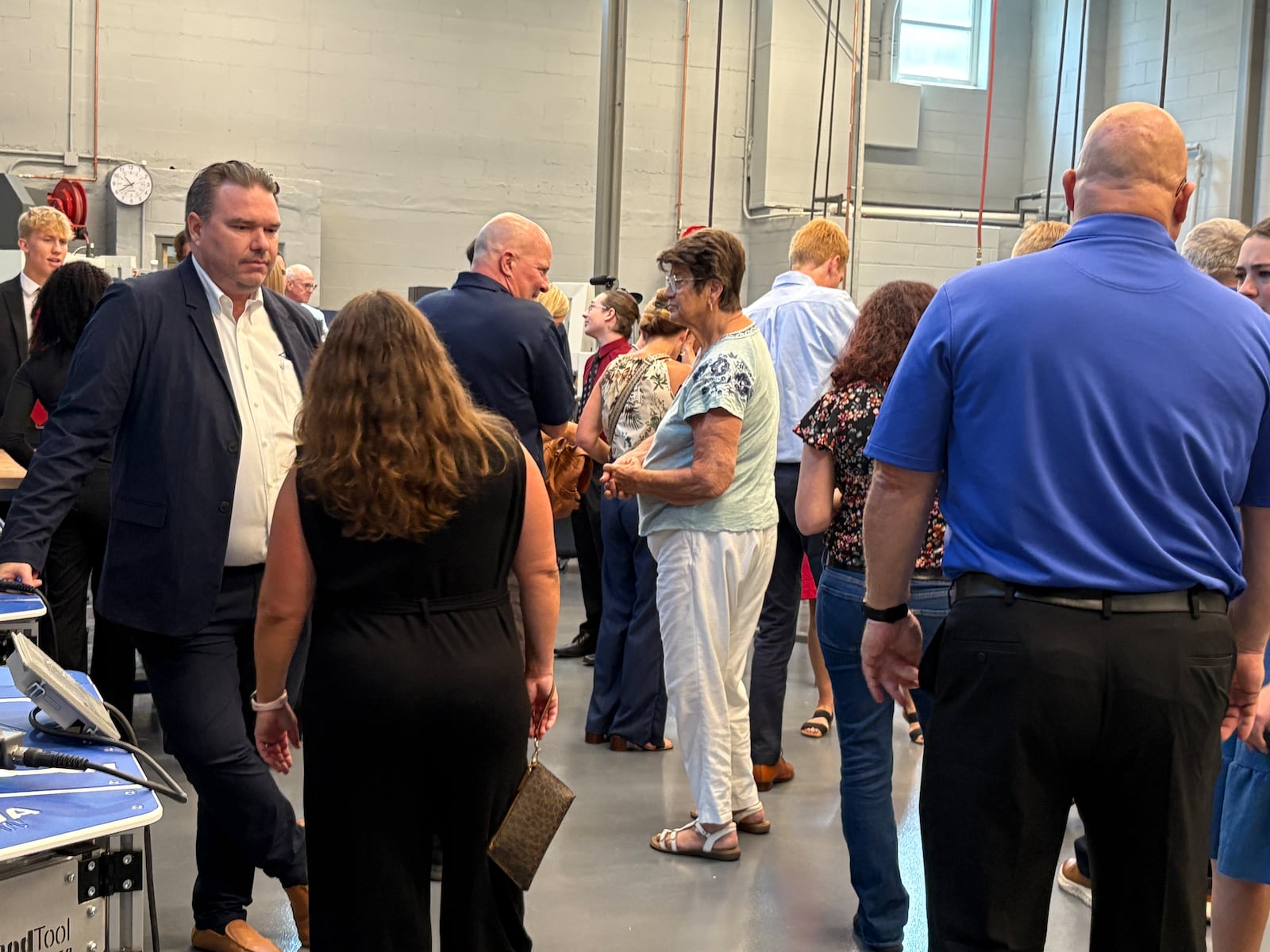 Local industry leaders, Kettering city officials and community members explore the updated engineering space during a Thursday, Aug. 7, 2025, grand opening celebration of the new advanced manufacturing program at Kettering Fairmont High School's Career Technology Center. JEN BALDUF/STAFF