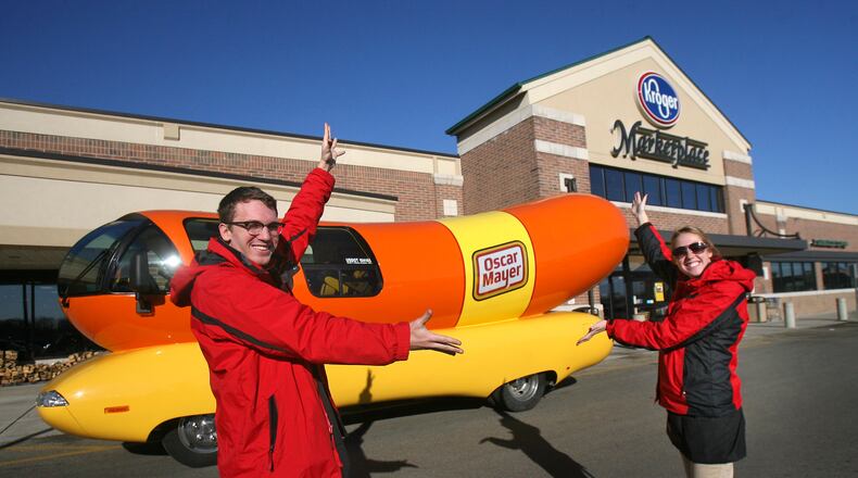 Hotdogger's Dylan Hackbarth (left) and Kylie Hodges stand with an Oscar Mayer Wienermobile outside the Kroger Marketplace in Liberty Twp., Ohio, Thursday, Jan. 6, 2012. This Wienermobile is one of a fleet of six vehicles touring the United States. The vehicle is 60 hot dogs in length (27 feet) and weighs 140,000 hot dogs (7 tons). Staff photo by Nick Daggy
