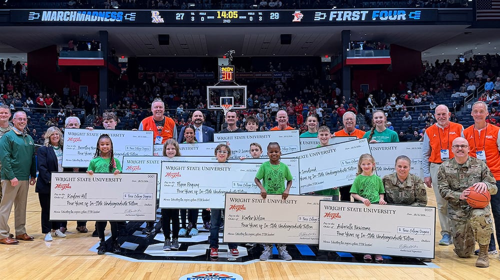 Students hold full-tuition scholarship checks on the court at the University of Dayton Arena during halftime of a NCAA First Four game on March 18, where Wright State University and the Big Hoopla recognized the STEM Challenge winners. WRIGHT STATE UNIVERSITY / PROVIDED