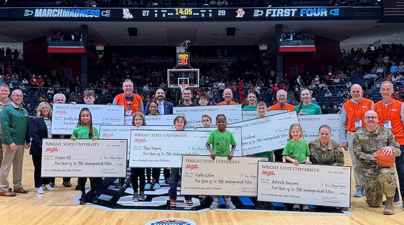 Students hold full-tuition scholarship checks on the court at the University of Dayton Arena during halftime of a NCAA First Four game on March 18, where Wright State University and the Big Hoopla recognized the STEM Challenge winners. WRIGHT STATE UNIVERSITY / PROVIDED