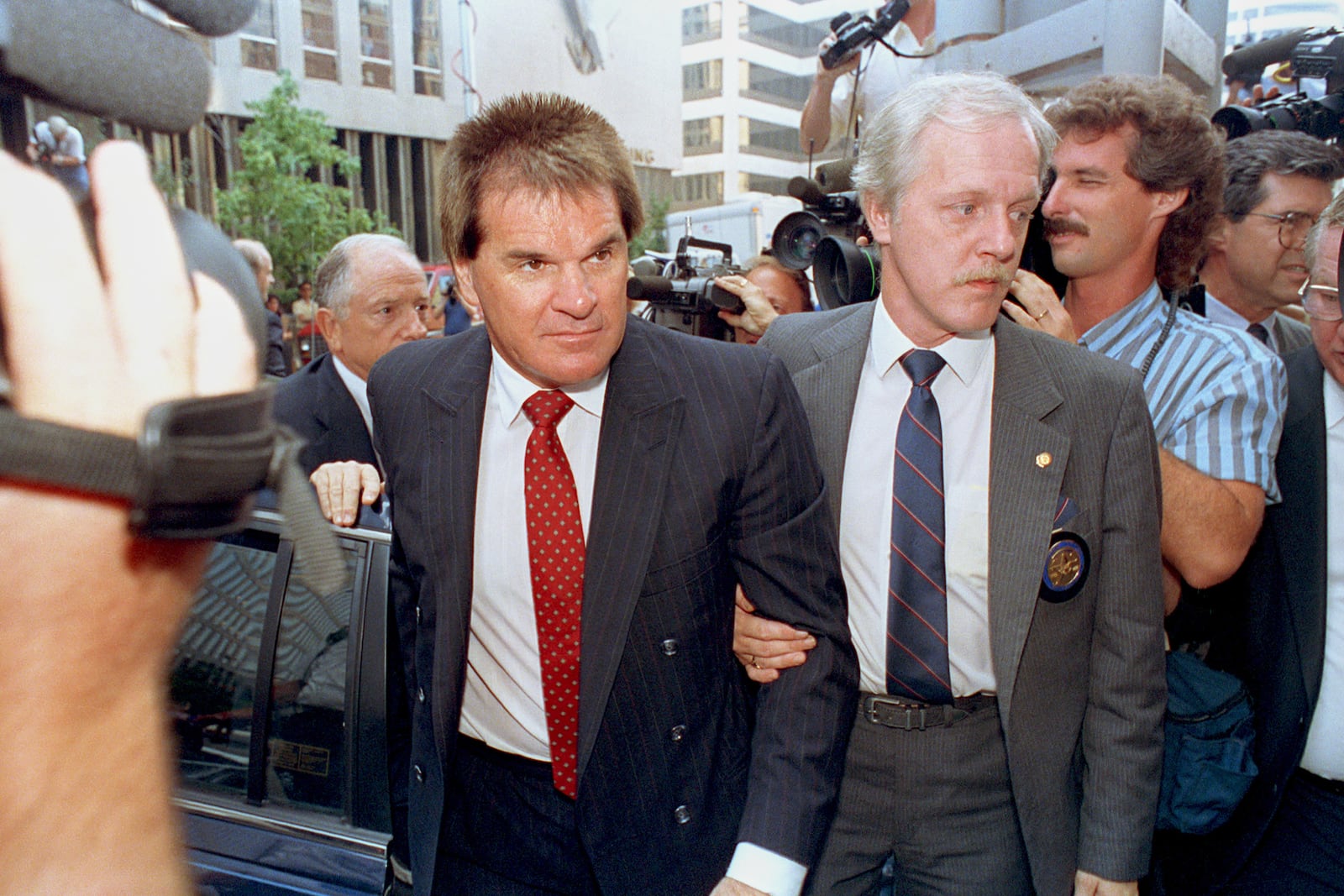 FILE - Former Cincinnati Reds manager Pete Rose is escorted by a Federal Marshal, right, as he arrives at federal court in Cincinnati, Ohio on July 19, 1990. (AP Photo/Mark Lyons, File)