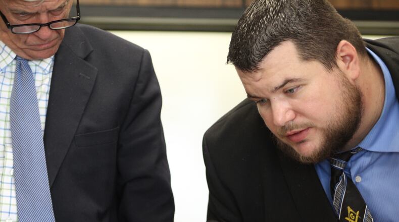 City of Dayton electrician David Shaver, right, examines a document submitted as evidence at his dismissal hearing this week. Shaver’s attorney, David Duwel, looks on. CORNELIUS FROLIK / STAFF