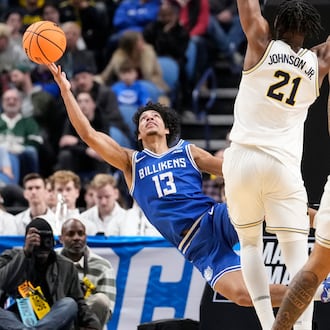 Saint Louis guard Dion Brown (13) attempts to shoot as he falls during the second half against Michigan in the second round of the NCAA college basketball tournament, Saturday, March 21, 2026, in Buffalo, N.Y. (AP Photo/Yuki Iwamura)