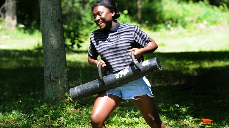 Joelle Staches, 13, carries the SWAT team door ram running the obstacle course Thursday July 28, 2022 at the Police and Youth Together Camp. MARSHALL GORBY\STAFF