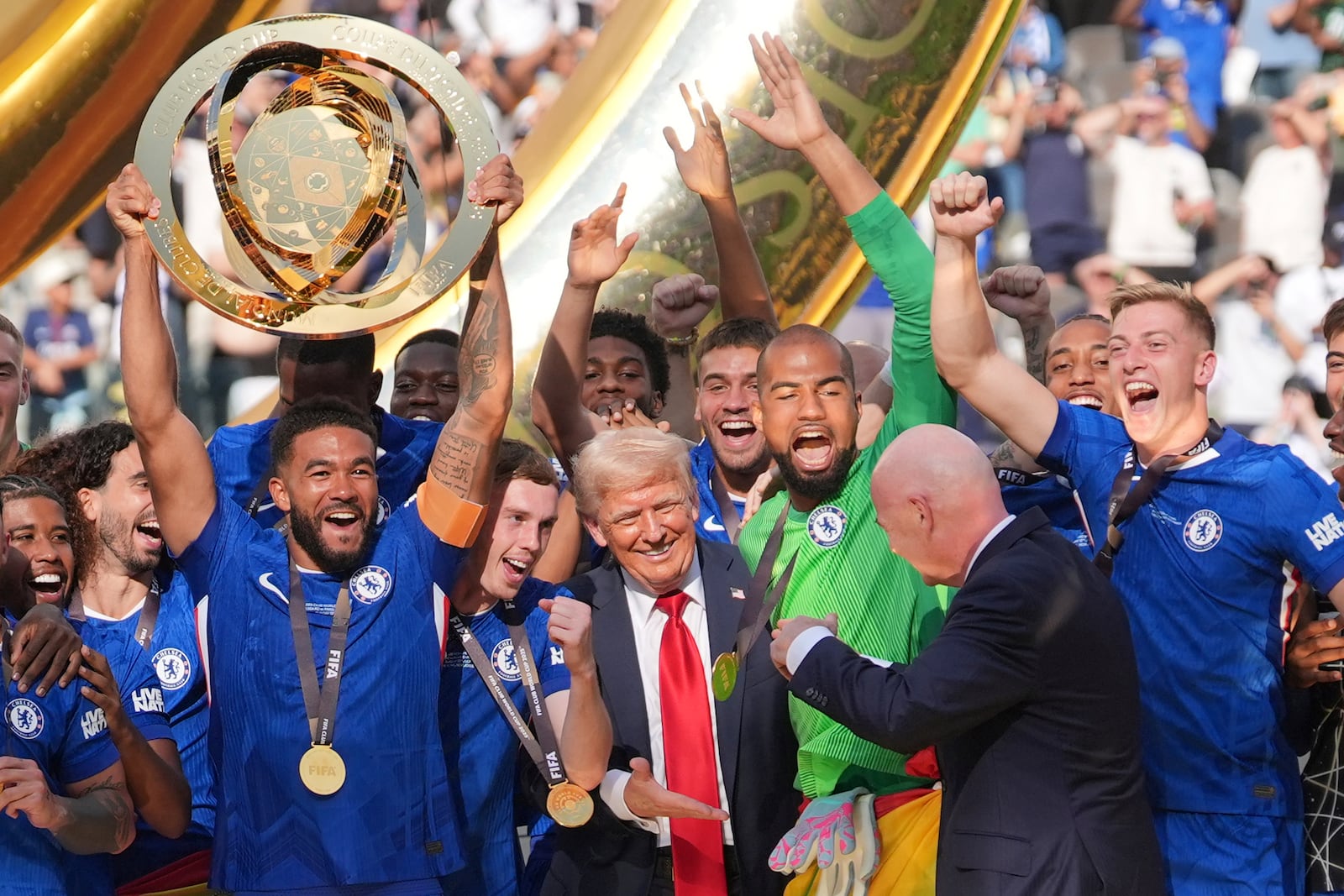 President Donald Trump reaches out to shake hands with FIFA President Gianni Infantino as Chelsea's Reece James (24) lifts the trophy following the Club World Cup final soccer match between Chelsea and PSG in East Rutherford, N.J., Sunday, July 13, 2025. (AP Photo/Seth Wenig)