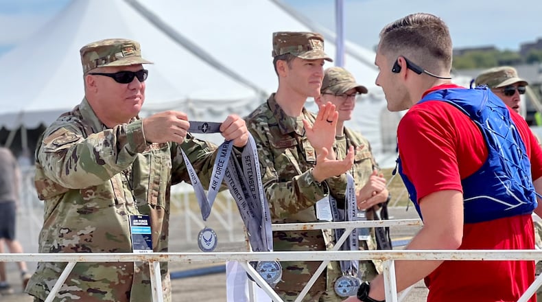 Participants in Saturday's 27th annual Air Force Marathon receive medals at the race's finish line on the grounds of the Air Force Museum. AIMEE HANCOCK/STAFF