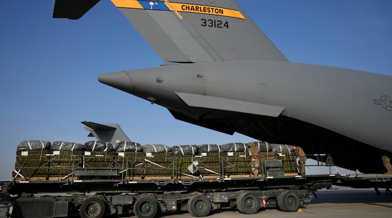 Members of the U.S. Air Force load containers of humanitarian aid into an airplane at Al-Udeid Air Base, Qatar, Friday, March 29, 2024, prior to dropping them over Gaza Strip. (AP Photo/Hussein Malla)