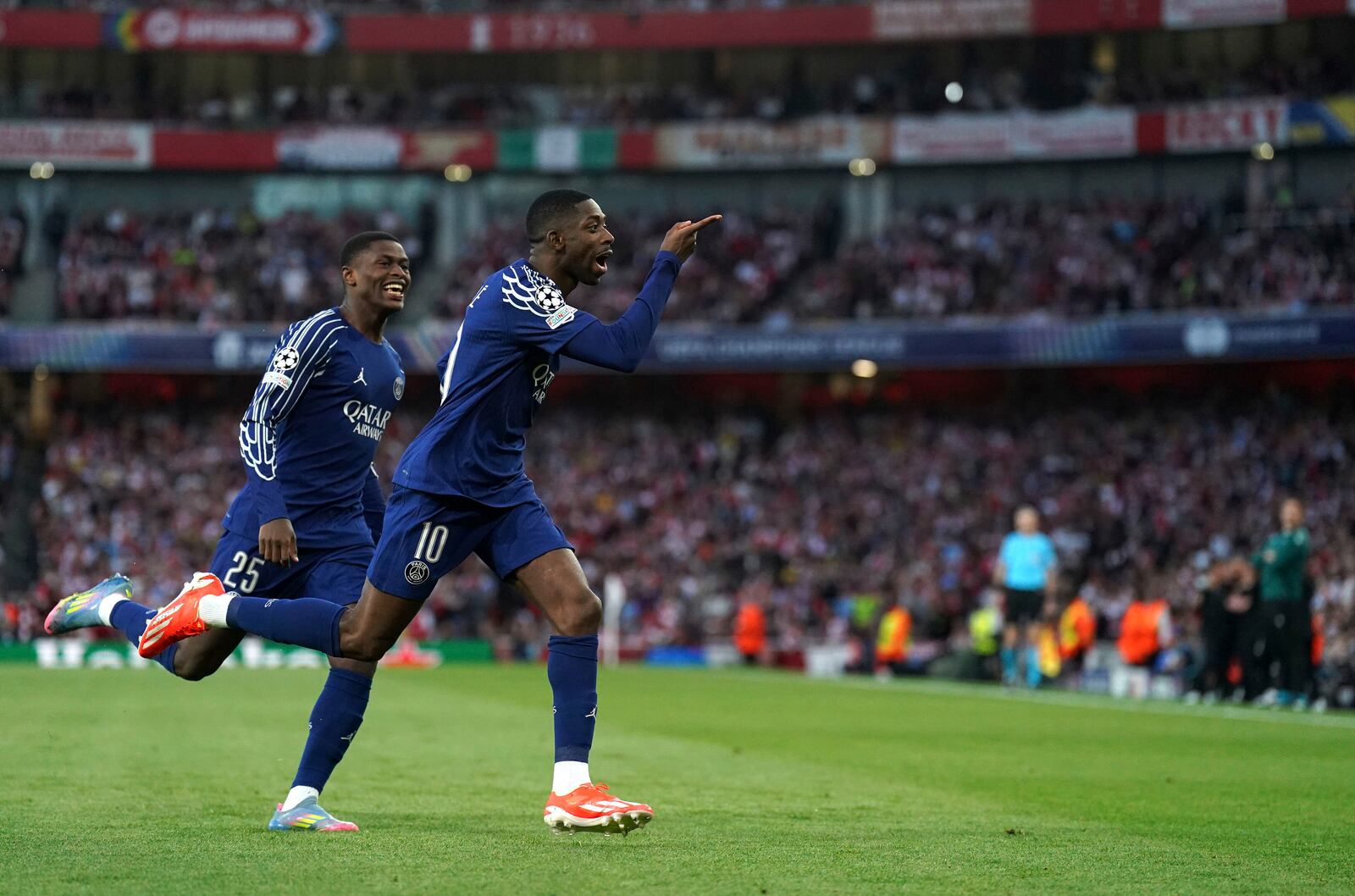 PSG's Ousmane Dembele, right, celebrates after scoring his side's opening goal during the Champions League semifinal first leg soccer match between Arsenal and Paris Saint-Germain at Emirates Stadium in London, England, Tuesday, April 29, 2025. (Adam Davy/PA via AP)