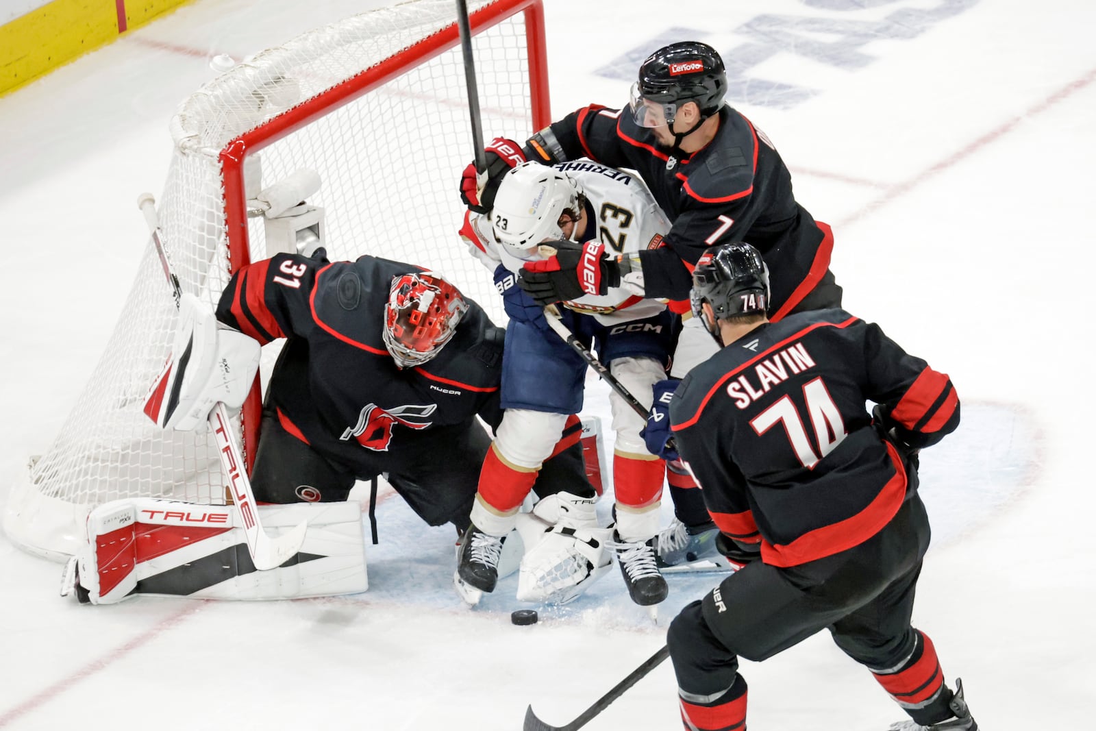Florida Panthers center Carter Verhaeghe (23) battles Carolina Hurricanes goaltender Frederik Andersen (31), defenseman Dmitry Orlov (7) and defenseman Jaccob Slavin (74) during the second period of Game 5 of the NHL hockey Stanley Cup Eastern Conference finals Wednesday, May 28, 2025, in Raleigh, N.C. (AP Photo/Chris Seward)